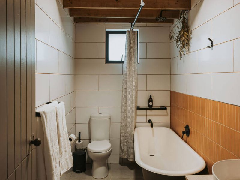 Bathroom with freestanding tub and white tiles at De Stilte