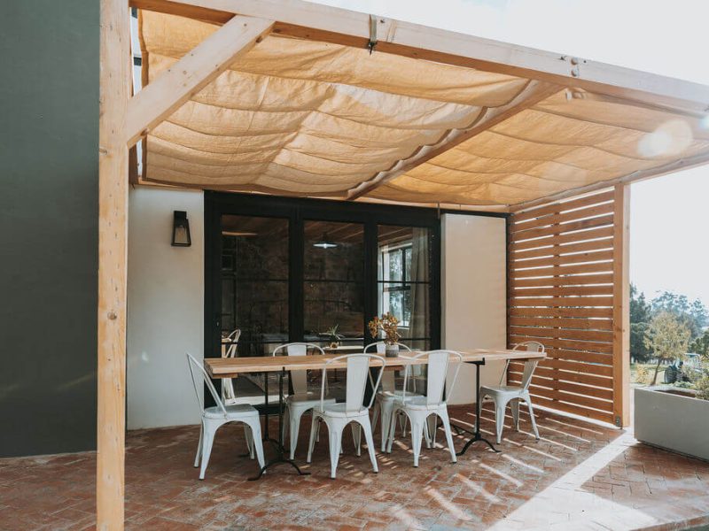 Outdoor dining space with canopy roof at De Stilte cottage.