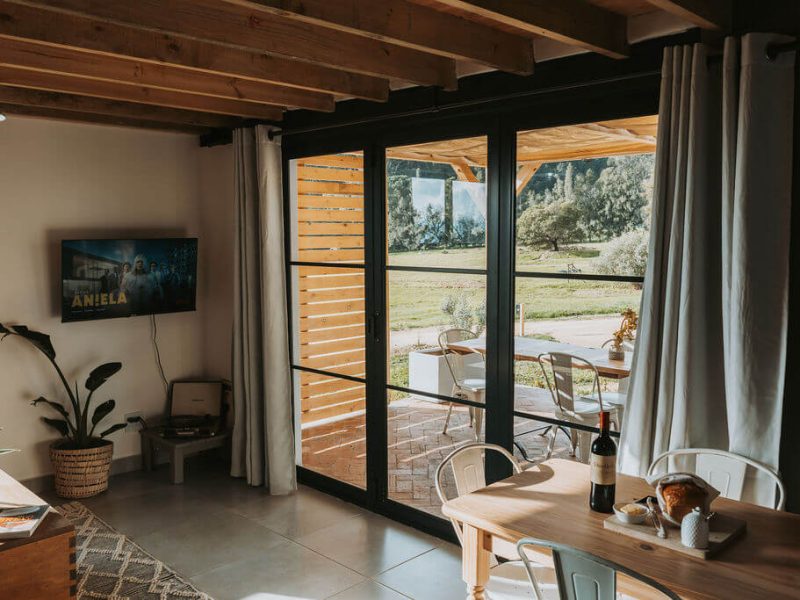 Open-plan living area with large windows and scenic view at De Stilte cottage.