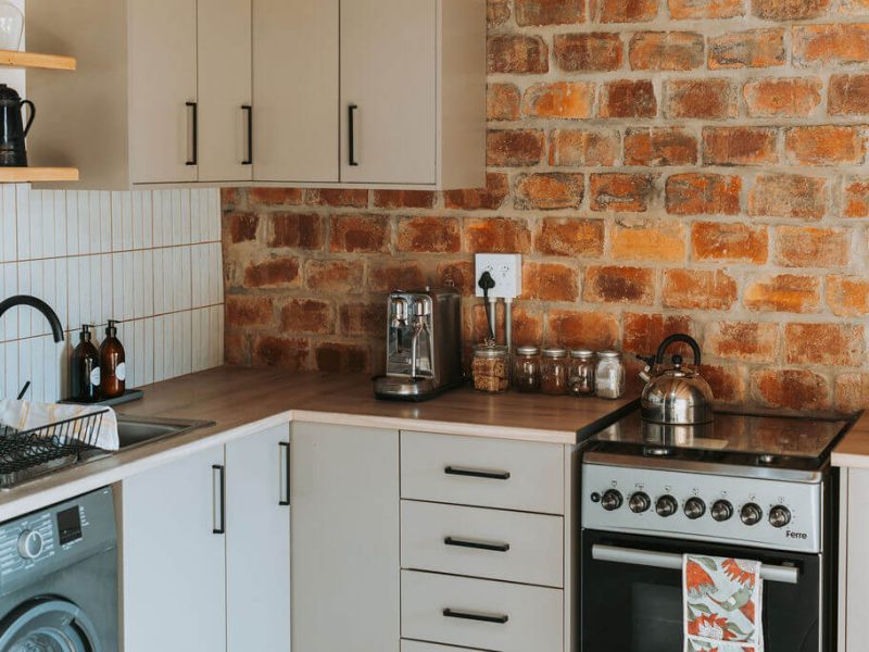 Rustic kitchen at De Stilte with brick backsplash and modern stove.