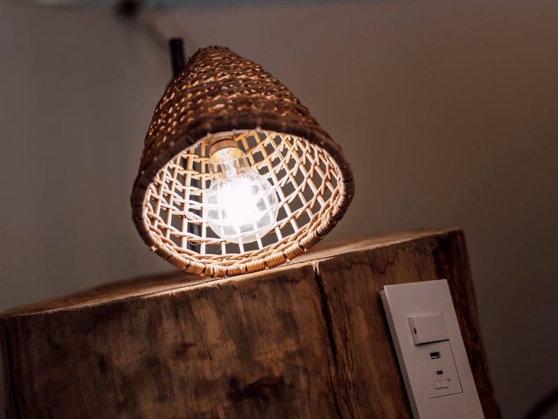Rattan light fitting and switch on wooden wall
