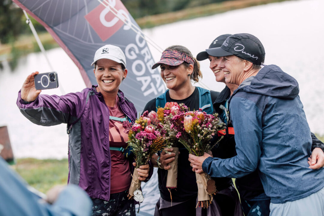 Group of cyclists smiling and holding flowers after event