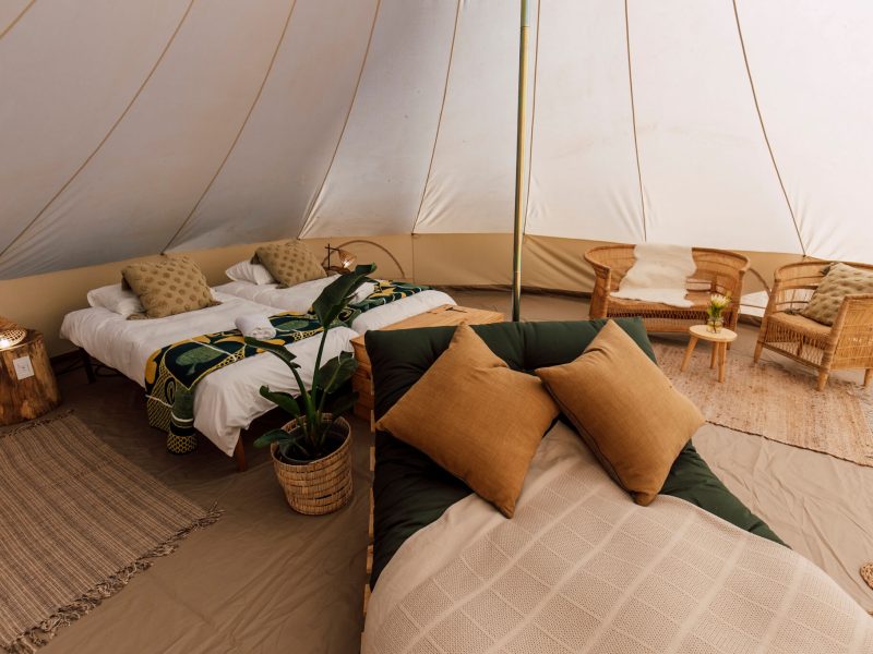 Bedding arrangement with cushions and throw inside canvas tent