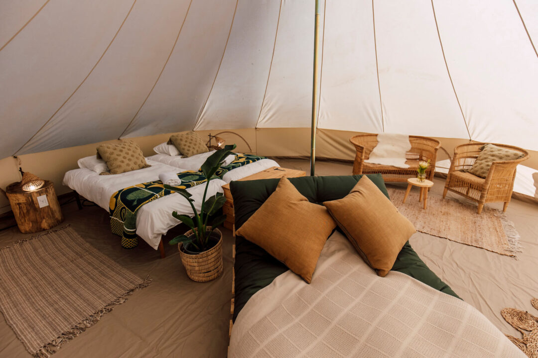 Bedding arrangement with cushions and throw inside canvas tent