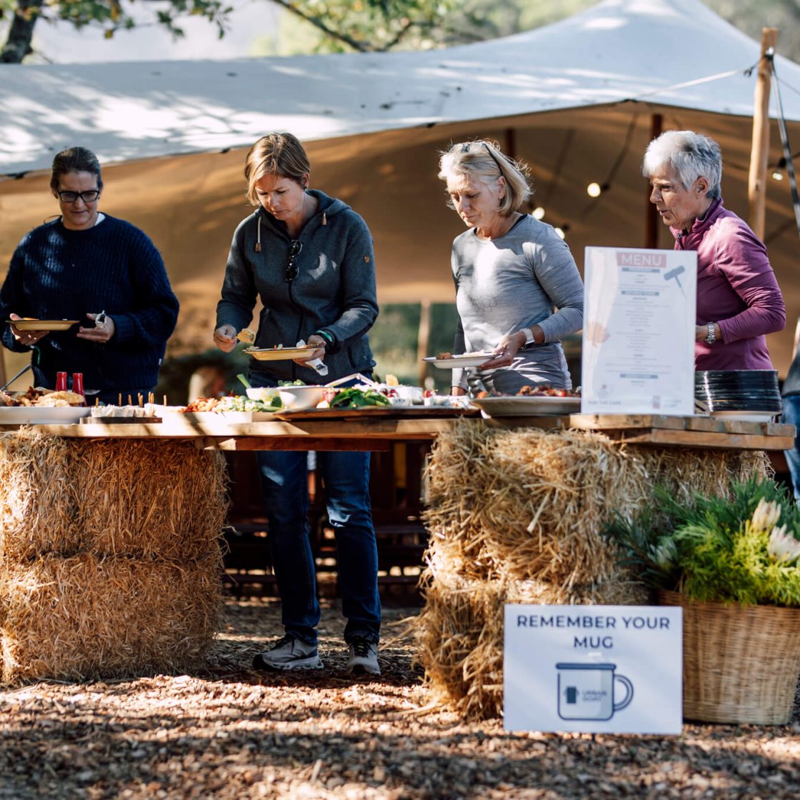 Guests gathered at an outdoor coffee stand with hay-bale setup at De Stilte